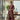 Woman in a patterned dress standing in an office with a cityscape view.