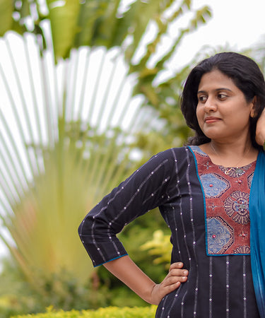Women wearing a black kurti with dupatta against a nature background