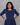 Woman wearing a blue checkered dress against a gray background