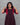 Woman wearing a wine red dress against a gray background