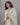 Woman wearing a light green kurti with a floral dupatta against a gray background