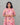 Woman wearing a pink floral maternity kurti against a gray background