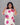 Woman wearing a white dress with pink floral patterns against a gray background