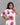 Woman wearing a white dress with pink floral patterns against a gray background