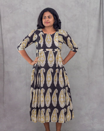 Woman wearing a patterned dress against a plain background