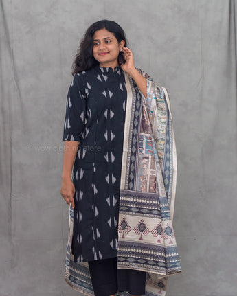 Woman wearing a black ikkat kurti with a printed dupatta against a gray background