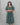 Woman wearing a green ikkat maternity kurti against a gray background