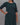 Dark green dress with subtle pattern worn by a person against a gray background