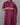 Person wearing a purple kurta with floral patterns on a gray background
