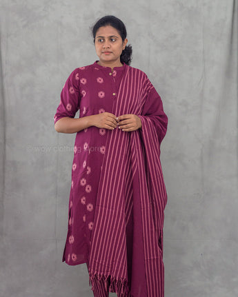 Woman wearing a purple traditional outfit with a matching dupatta against a gray background