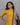 Woman wearing a yellow jacquard kurti with a kalamkari dupatta against a gray background