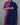 Person wearing a blue and pink traditional outfit against a gray background