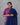 Woman wearing a blue and pink traditional outfit against a gray background