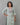 A lady wearing a plain top with elegant neck work linen kurti on a grey background