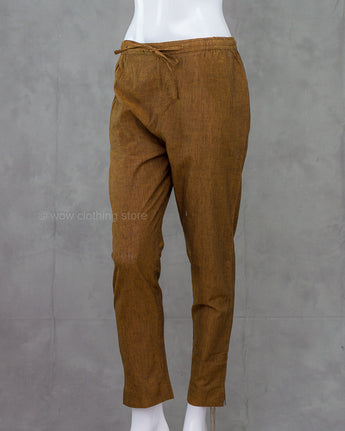 Brown cotton pants on a mannequin against a gray background