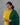 Woman wearing a yellow kurta with green dupatta against a gray background