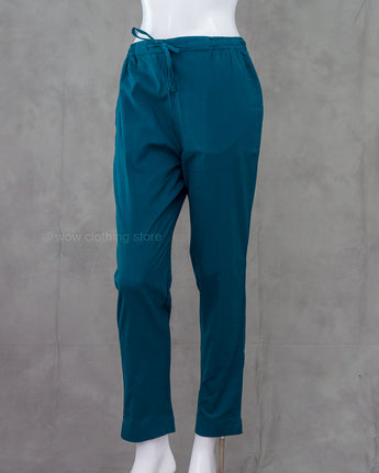 Dark teal pants on a mannequin against a gray background