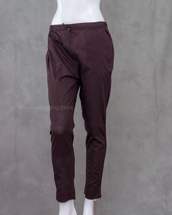 Deep brown cotton pants on a mannequin against a gray background
