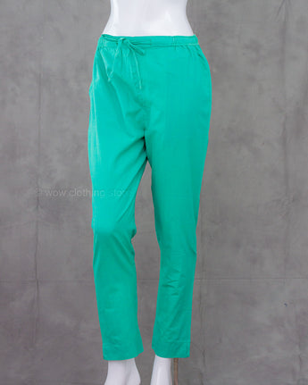 Turquoise cotton pants on a mannequin against a gray background