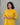 A women wearing a plain yellow kurti with mirror work and plain bottom