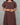 Brown dress with puff sleeves worn by a person on a gray background