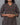 Person wearing a patterned kurta against a gray background