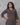 Woman wearing a patterned dress with a gray background