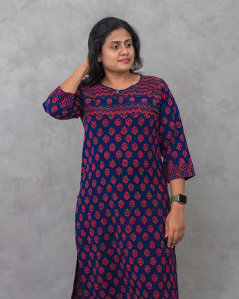 A women wearing a navy blue printed cotton kurti on a grey background