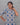 Woman wearing a patterned dress against a gray background