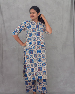 Woman wearing a patterned co-ord kurti set with against a plain background