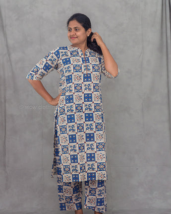 Woman wearing a patterned co-ord kurti set with against a plain background