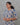 Woman wearing a patterned kurti against a gray background