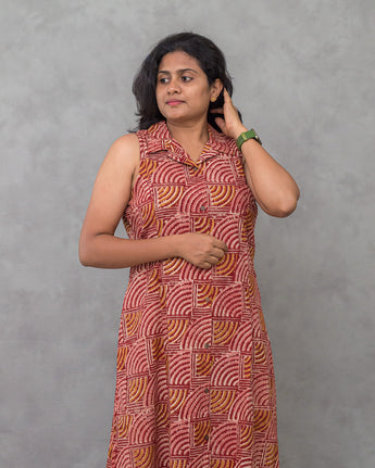A women wearing a kalamkari printed pure cotton collored kurti on a grey background