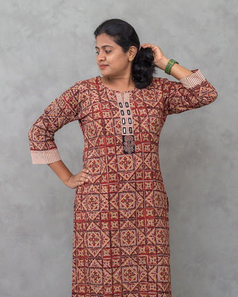 Woman wearing a patterned dress against a gray background