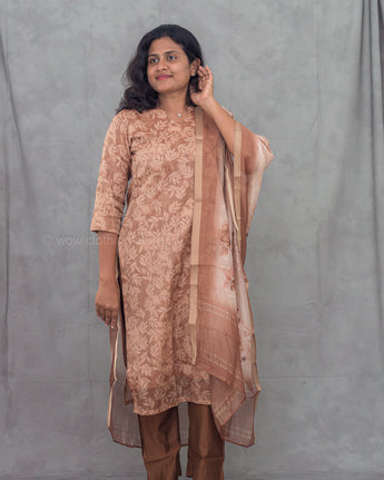 Woman wearing a brown traditional kurti with a plain background