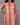 Person wearing a pink and beige striped dress against a gray background