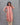 Woman wearing a pink and beige striped kurti against a gray background