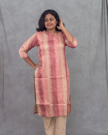 Woman wearing a pink and beige striped kurti against a gray background