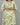 Green and white patterned dress worn by a person on a gray background