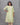 Woman wearing a green and white floral patterned kurti against a gray background