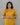 Woman wearing a mustard yellow kurta set with floral embroidery against a gray background