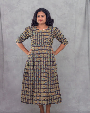 Woman wearing a patterned dress against a gray background