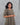 Woman wearing a patterned dress against a gray background