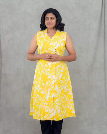 A women wearing yellow color cotton a-line kurti with back rope on a grey background