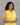 A women wearing yellow color cotton a-line kurti with back rope on a grey background