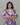 Woman wearing a purple and white patterned dress against a gray background