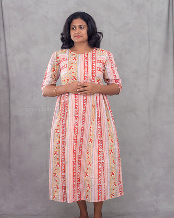 Woman wearing a patterned dress against a gray background