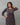 A lady wearing a printed black cotton kurti on a grey background