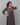 A lady wearing a printed black cotton kurti on a grey background