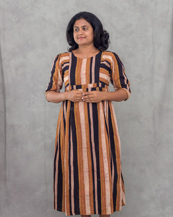 Woman wearing a striped dress against a gray background